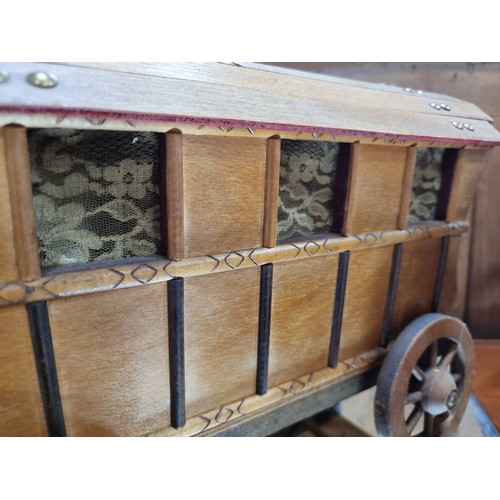 443 - A charming, handmade wooden model of a traditional caravan with fully functioning wheels and crochet... 