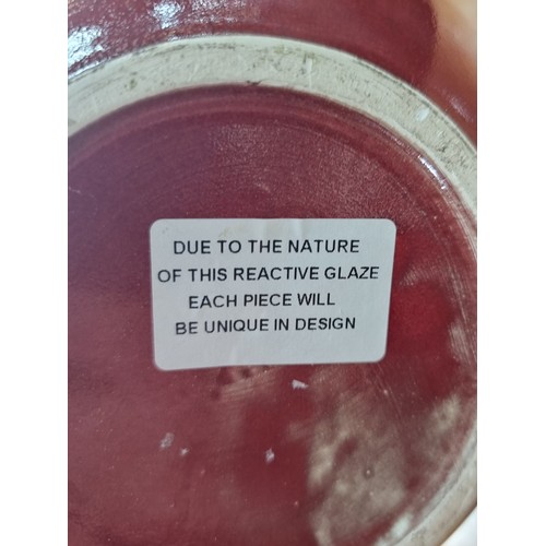 454 - A large, striking ceramic vase with a gently tapered neck and a blood red glaze with grey and cream ... 