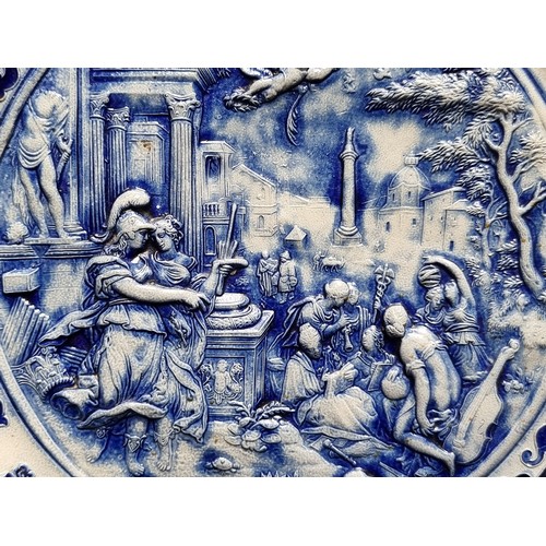 304 - A large circular stoneware plate, featuring a classical scene in high relief to centre with a lavish... 