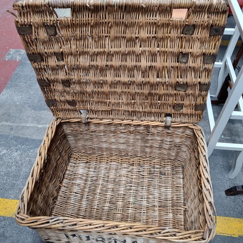 356 - A large vintage wicker basket with metal reinforcements and hinged lid. H34cm, L75cm, D54cm.