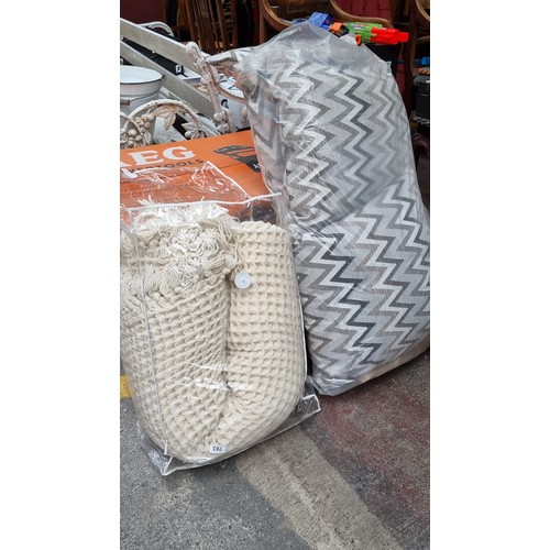 344 - Two bags containing excellent homeware textiles. Including a large example of an expertly knitted bl... 