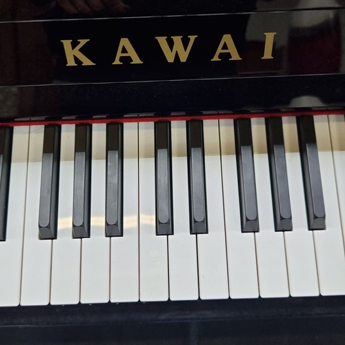 400 - Star Lot: A stunning, top quality upright piano by Kawai with a black glossy finish. Comes with orig... 