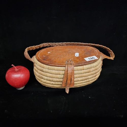 186 - A beautiful vintage handwoven fishing box with leather plaid handle and lid.