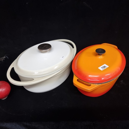 196 - A set of 2 cast iron cassarole dishes with lids, one in a red orange colour an off-white example mad... 