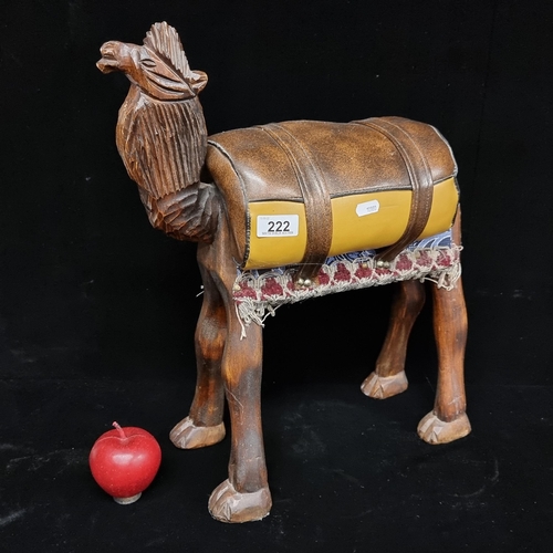 222 - A large hand-carved camel figure with a leather-upholstered saddle bag and a fabric saddle pad. A ch... 