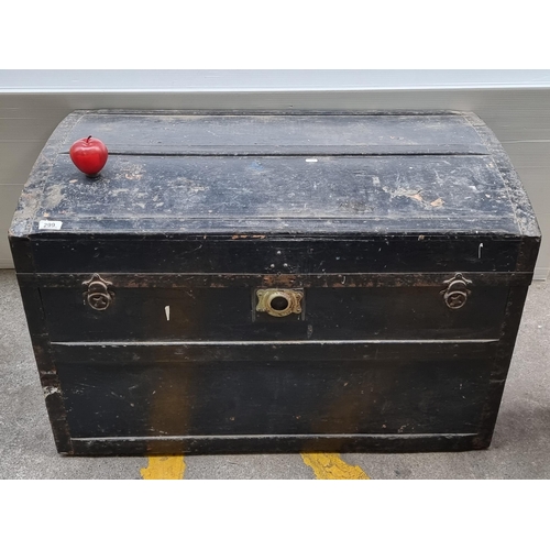 299 - A huge antique travel chest with domed top, metal reinforcements, leather handles and brass clasp. A... 