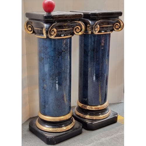 338 - A pair of Roman column ceramic plant stands, in a blue marble, black and gilt finish.