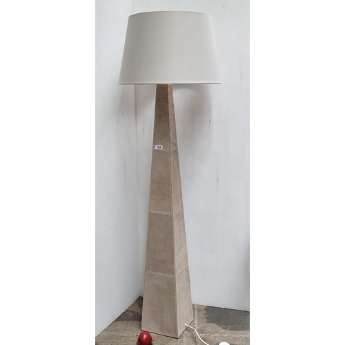 368 - A large beige floor lamp with a suede, pyramid shape finish. With a broad shade.