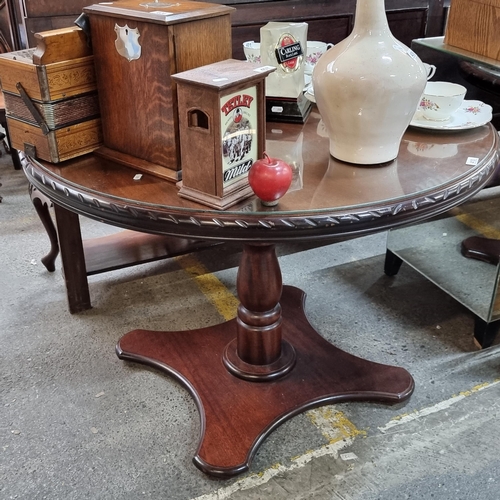 410 - A nice circular dining table with single turned column, a splayed base and a glass heat saver top.