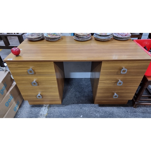 A good sized Mid century modern wooden desk with six deep drawers and finished with sleek chrome handles.