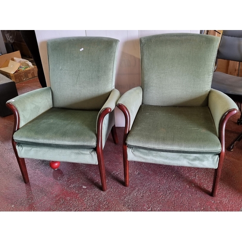 666 - A pair of mid century Parker Knolls Froxfield fire side chairs in a cypress green upholstery and bee... 