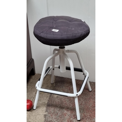 695 - A height adjustable potter's stool, in a white enamel finish and with a removable cushion. In a cool... 