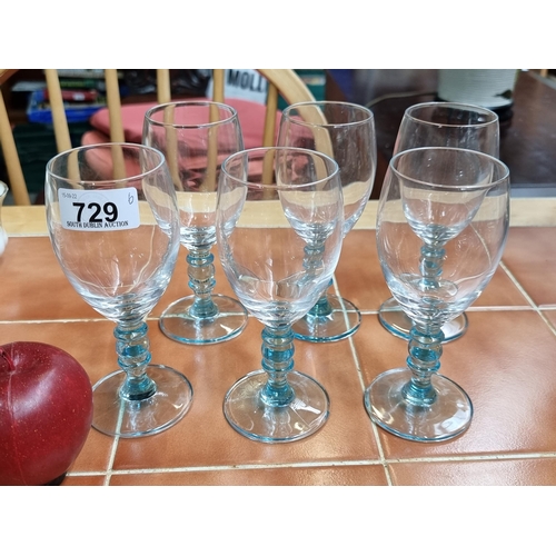 729 - A six-piece set of hand blown wine glasses with blue toned stems.