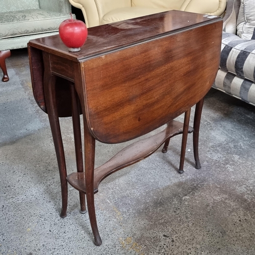 777 - An elegant drop-leaf, gate leg table with elegant sabre legs and a carved stretcher.