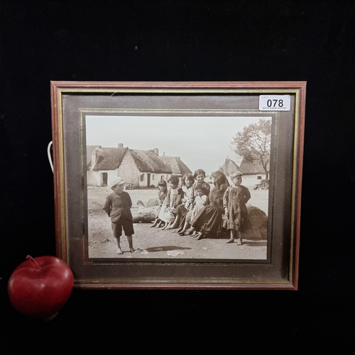 78 - An original vintage photograph dating to the early 20th century featuring a group of children in tra... 