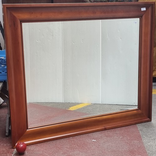 203 - A very large and heavy antique bevelled mirror housed in a wooden frame with a rich colour to the wo... 