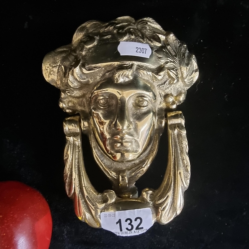 132 - A vintage heavy brass door knocker, finely moulded as a mask of the Greek goddess Athena. A very wel... 