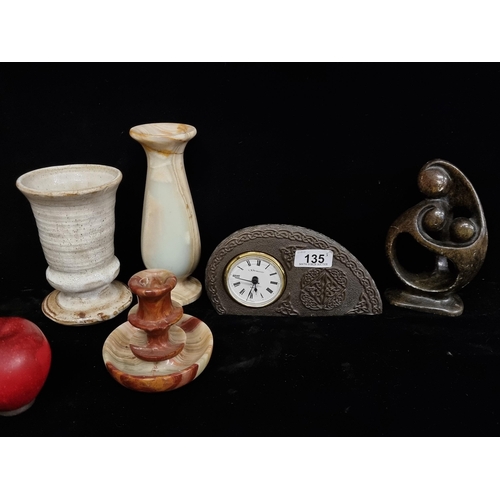 135 - A marvellous selection of ornamental items, including a heavy onyx vase and candle holder, both feat... 