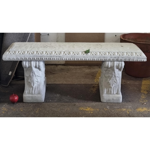 584 - A heavy, quality reconstituted stone garden bench with classical carved edges and legs.