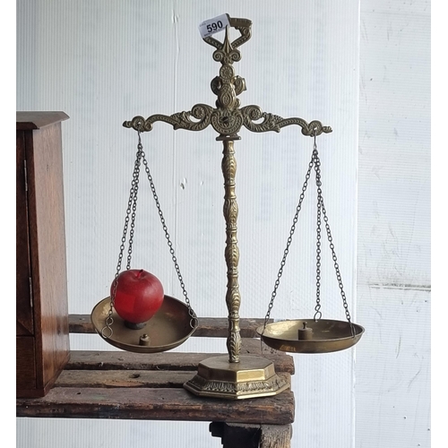 590 - An ornate set of brass balance scales, in working condition. With two small weights.