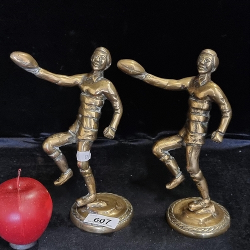 607 - A pair of vintage heavy brass rugby trophies, marked to base.