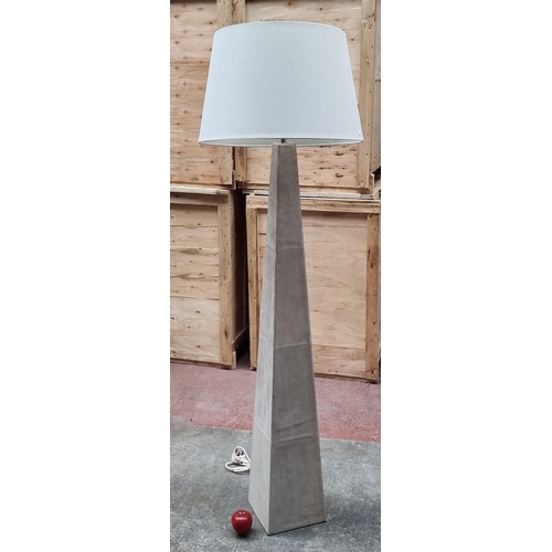 732 - A large beige floor lamp with a suede, pyramid shape finish. With a broad shade.