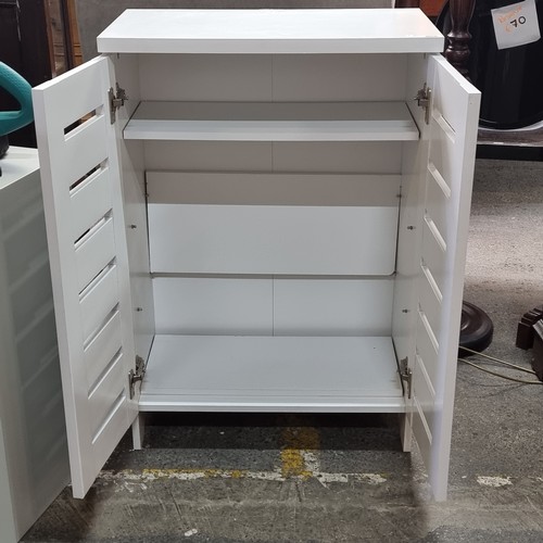 408 - A good sized wooden cabinet with internal shelf and slatted doors. In a white matte finish.