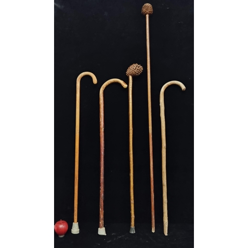 236 - Five vintage wooden walking sticks including two with cone handles.