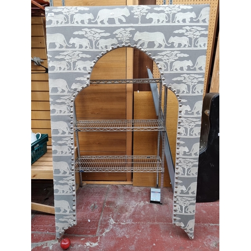 342 - Star lot : An Indian arched window frame, upholstered in a soft grey fabric with wildcat fabric. An ... 