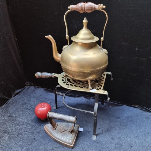 421 - Three antique domestic items including a brass tea kettle, a large victorian  brass fireplace trivet... 