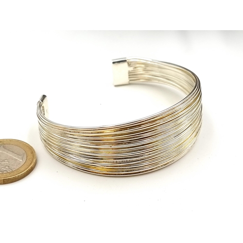 48 - A sterling silver ribbed sleek design Torc bracelet. Weight: 26.05 grams.