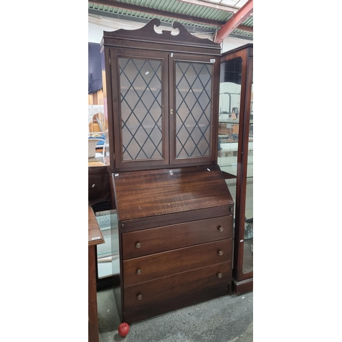 573 - A vintage marriage comprising of a vintage bureau base, with an leaded window bookcase top featuring... 