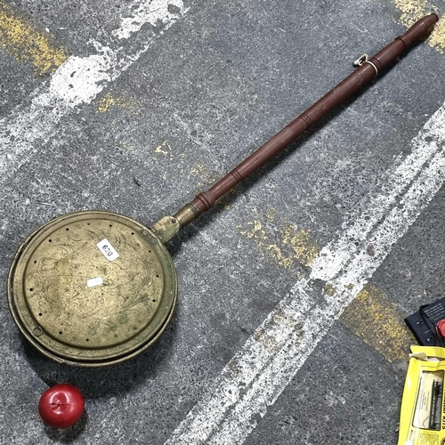 620 - An antique long-handled bed warmer. With brass pan and turned wooden shaft. Featuring incised bird m... 