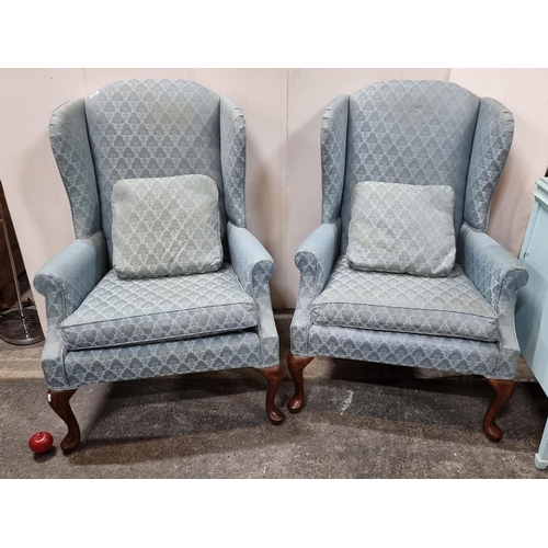 681 - Star Lot : Two wingback armchairs with wooden cabriole legs and a demask light blue upholstery, each... 