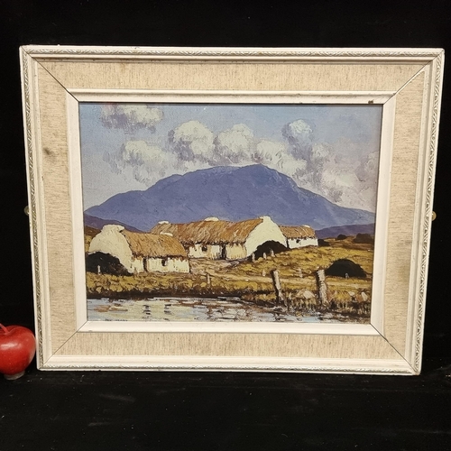 76 - A good sized print of a Paul Henry work housed in a cream frame.