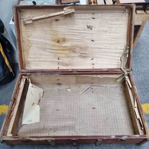 389 - A very large antique canvas bound wooden suitcase with wood and iron reinforcements and iron clasps.