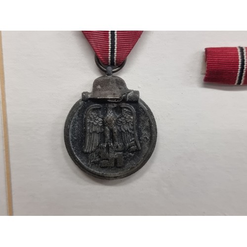 75 - A fantastic original framed example of a German Eastern Medal along with the award letter. The Easte... 