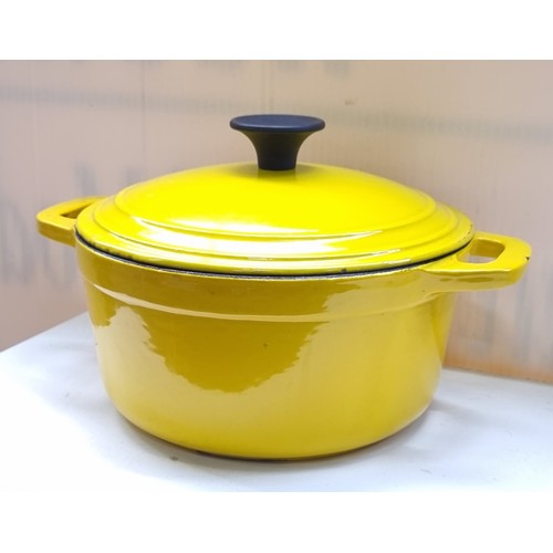 452 - Four useful domestic items including a heavy, cast metal heavy casserole enamelled in a bright yello... 