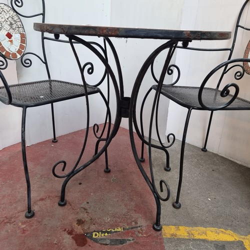 360 - A fabulous heavy outdoor dining set including circular wrought iron table with mosaic top and two wr... 