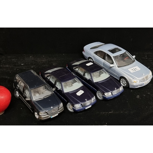 121 - A collection of four collectable model Mercedes cars. Including a Mercedes Benz S-Class (1/18) by Ma... 