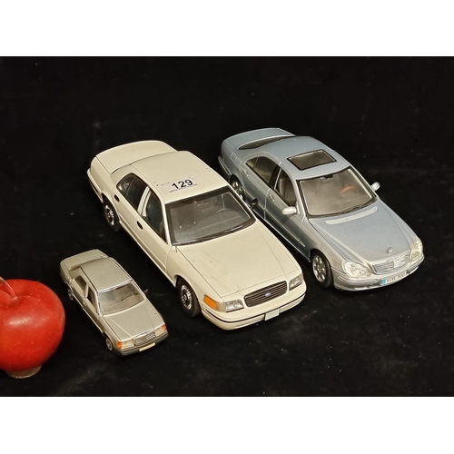 129 - A selection of three model cars including a Ford Crown Victoria (1/18) by AutoArt. An unusual exampl... 