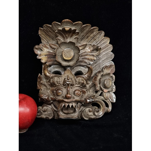 189 - An unusual and very impressive carved wooden wall hanging, of Balinese origin, carved in the style o... 