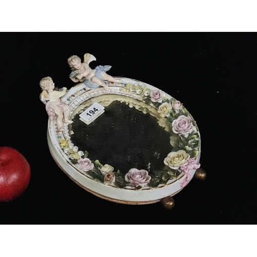 194 - An unusually heavy, porcelain, freestanding mirror, lavishly decorated after Meissen with relief det... 