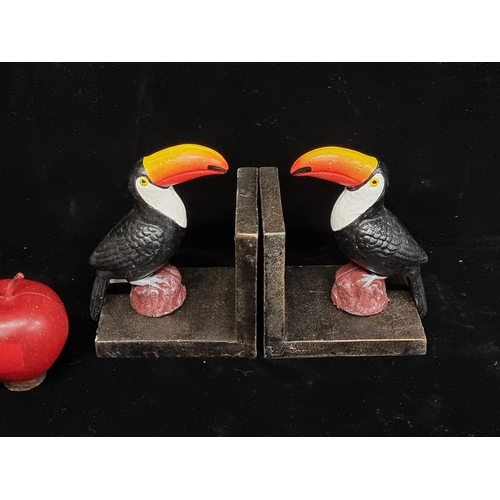 201 - A heavy pair of cast metal bookends featuring the iconic Guinness toucan, with hand painted detail.