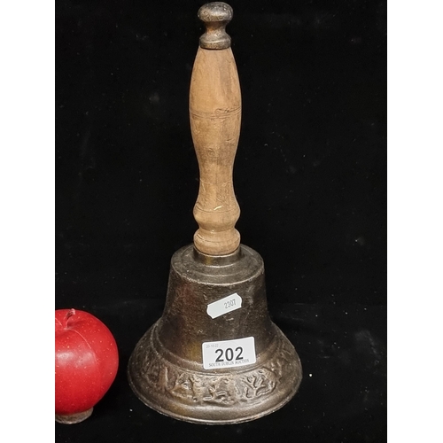 202 - A cast metal hand bell with singing bird motif and turned wooden handle.