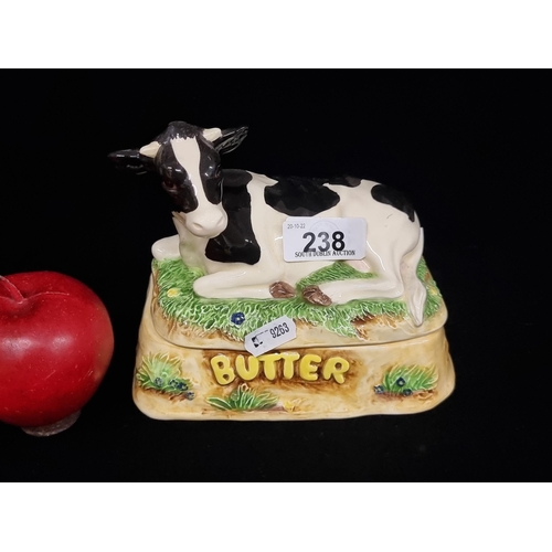 238 - A charming ceramic butter dish with a large Friesian cow figure to lid and realistic colour palette.... 