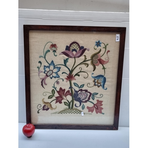 274 - A delightful antique embroidery artpiece featuring stylised flowers in bountiful colour. Housed in w... 