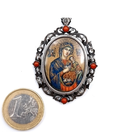 46 - A continental Victorian silver pendant/ brooch, containing a religious icon. Set with a coral stone ... 