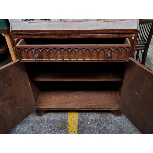 491 - A vintage writing desk with ornate carvings. The top opens to reveal eight pigeon holes and a drawer... 