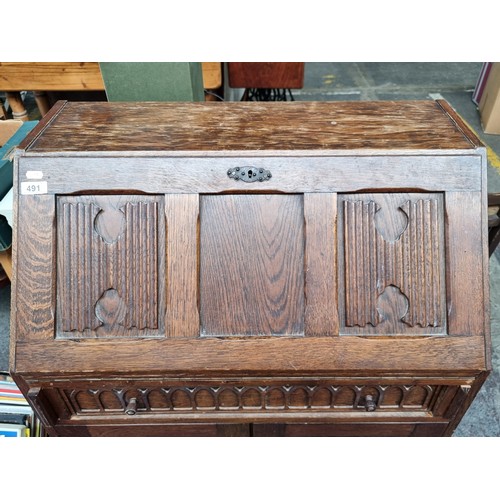 491 - A vintage writing desk with ornate carvings. The top opens to reveal eight pigeon holes and a drawer... 